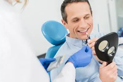 man trying to pick a color for his new dental veneers