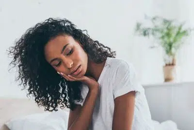 woman holding her mouth due to tooth pain