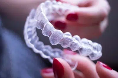 woman holding her clear aligners