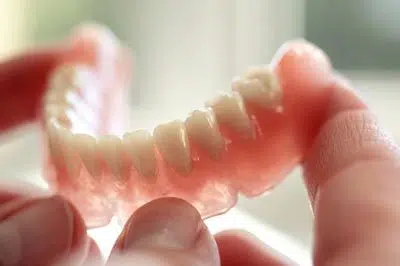 person holding dentures